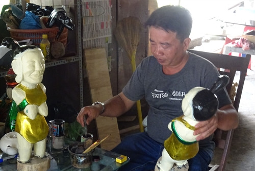 Nghệ nhân Phùng Quang Oánh chế tác những những nhân vật rối nước truyền thống. Ảnh: Gia Thuận - TTXVN Nghệ nhân Phùng Quang Oánh chế tác những những nhân vật rối nước truyền thống. Ảnh: Gia Thuận - TTXVN