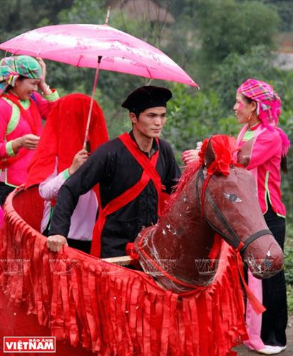 Cô dâu được chị gái chuẩn bị trang phục trong ngày cưới. Chú rể dùng ngựa giấy đi đón cô dâu. Nhà trai cử một người phụ nữ to khỏe cõng cô dâu về nhà trai. Cô dâu chú rể được thầy cúng dùng nước té lên người để đuổi tà ma trước khi lên đường sang nhà trai. Cô dâu được nhà trai đón về nhà làm lễ. Chú rể mở tấm khăn đỏ khi đón cô dâu về phòng cưới. Cô dâu về nhà chồng, cởi băng đỏ cho chú rể. Cô dâu được chị gái chuẩn bị trang phục trong ngày cưới. Chú rể dùng ngựa giấy đi đón cô dâu. Nhà trai cử một người phụ nữ to khỏe cõng cô dâu về nhà trai. Cô dâu chú rể được thầy cúng dùng nước té lên người để đuổi tà ma trước khi lên đường sang nhà trai. Cô dâu được nhà trai đón về nhà làm lễ. Chú rể mở tấm khăn đỏ khi đón cô dâu về phòng cưới. Cô dâu về nhà chồng, cởi băng đỏ cho chú rể.