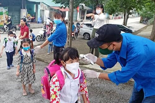 Ngày đầu tiên học sinh, sinh viên Quảng Ninh đi học trở lại được kiểm tra thân nhiệt trước khi vào lớp. Ảnh: TTXVN
