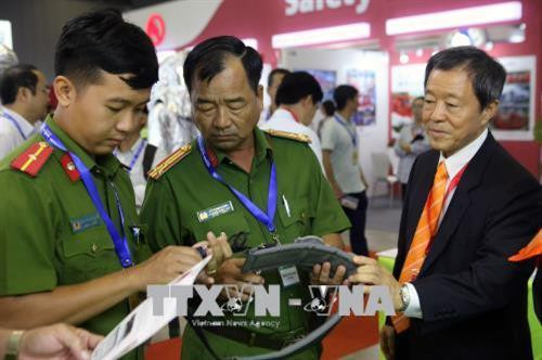 Cảnh sát PCCC nghiên cứu những thiết bị chữa cháy tại hội thảo. Ảnh: Thành Chung - TTXVN