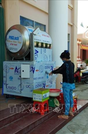 Người dân nhận gạo miễn phí tại cây "ATM gạo" được đặt ở UBND phường An Thạnh, thị xã Hồng Ngự. Ảnh: TTXVN phát