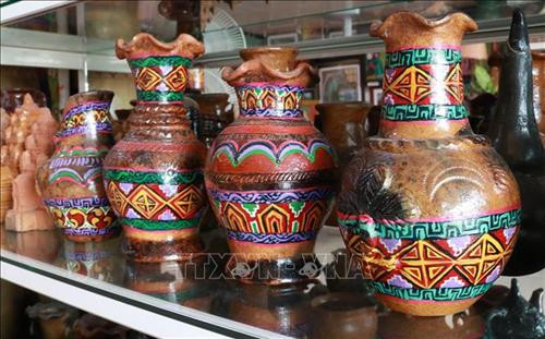 Bình gốm Bàu Trúc với sắc màu và họa tiết bắt mắt được nữ họa sĩ Chế Kim Trung thiết kế. Ảnh: Nguyễn Thành – TTXVN Bình gốm Bàu Trúc với sắc màu và họa tiết bắt mắt được nữ họa sĩ Chế Kim Trung thiết kế. Ảnh: Nguyễn Thành – TTXVN