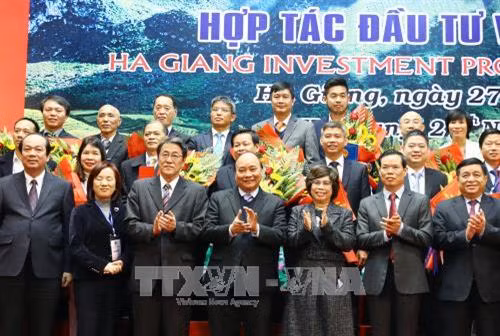 Thủ tướng Nguyễn Xuân Phúc chúc mừng các doanh nghiệp nhận cam kết đầu tư và nhận Giấy chứng nhận đầu tư vào tỉnh Hà Giang. Ảnh: Thống Nhất –TTXVN