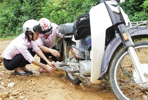 Những buổi trực tiếp đi cơ sở như thế này đã trở nên quá quen thuộc với cán bộ NHCSXH vùng cao. Đôi khi họ phải kiêm luôn là thợ sửa xe không kém phần lành nghề