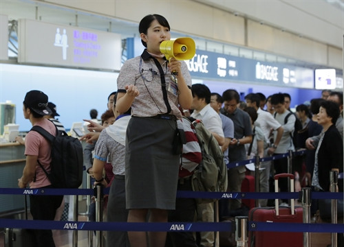 Nhân viên hàng không hướng dẫn hành khách tại sân bay quốc tế Tokyo ở Haneda, thủ đô Tokyo, ngày 20/9. EPA/TTXVN Nhân viên hàng không hướng dẫn hành khách tại sân bay quốc tế Tokyo ở Haneda, thủ đô Tokyo, ngày 20/9. EPA/TTXVN