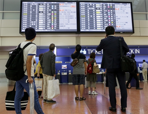 Hành khách kiểm tra thông tin chuyến bay tại sân bay quốc tế Tokyo ở Haneda, thủ đô Tokyo, Nhật Bản . EPA/TTXVN Hành khách kiểm tra thông tin chuyến bay tại sân bay quốc tế Tokyo ở Haneda, thủ đô Tokyo, Nhật Bản . EPA/TTXVN