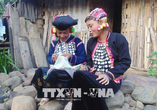 Người Si La truyền dạy cách thêu thùa, tạo hoa văn trên trang phục truyền thống của dân tộc cho con cháu trong bản. Ảnh: Xuân Tiến-TTXVN