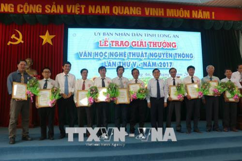 Phó Bí thư Tỉnh ủy Đỗ Hữu Lâm và Phó Chủ tịch UBND Long An Phạm Văn Cảnh, trao giải thưởng cho các tác giả đạt giải. Ảnh: Trần Thanh Bình-TTXVN