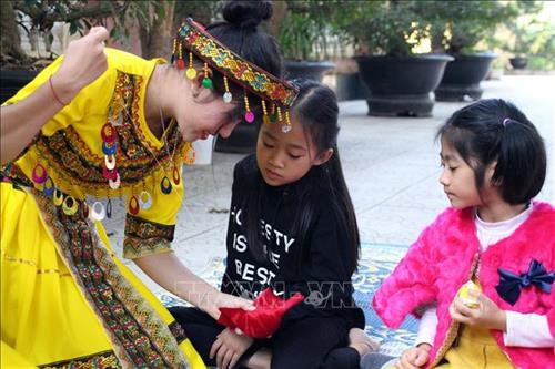 Học sinh được hướng dẫn cách thêu hoa văn thổ cẩm trên trang phục của đồng bào dân tộc Mông. Ảnh: Diệp Anh - TTXVN