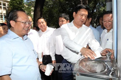 Bí thư Thành ủy Đinh La Thăng và các đồng chí trong đoàn công tác dùng thử nước sạch uống tại vòi. Ảnh: Thanh Vũ – TTXVN Bí thư Thành ủy Đinh La Thăng và các đồng chí trong đoàn công tác dùng thử nước sạch uống tại vòi. Ảnh: Thanh Vũ – TTXVN