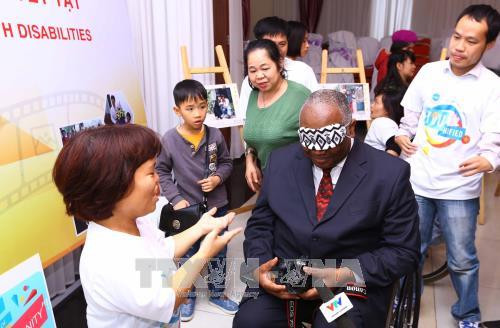 Đại biểu tham gia tiết mục bịt mắt chụp ảnh của dự án “Truyền thông về quyền của người khuyết tật” tại buổi mít tinh. Ảnh: Quang Quyết-TTXVN Đại biểu tham gia tiết mục bịt mắt chụp ảnh của dự án “Truyền thông về quyền của người khuyết tật” tại buổi mít tinh. Ảnh: Quang Quyết-TTXVN