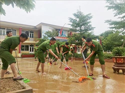 Các cán bộ chiến sĩ công an trên địa bàn tỉnh Quảng Bình hỗ trợ các trường học ở vùng lũ của huyện Minh Hóa, Tuyên Hóa, thị xã Ba Đồn…khắc phục hậu quả mưa lũ. Ảnh: TTXVN