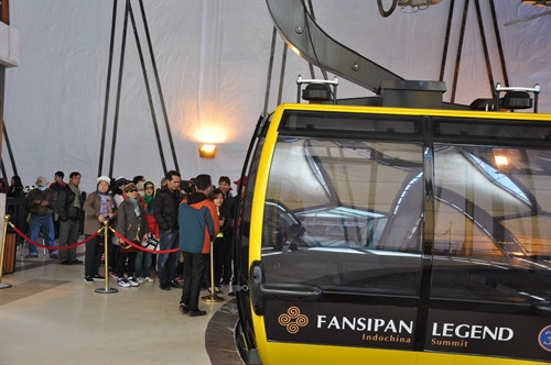 Du khách xếp hàng vào ca-bin để xuống núi.