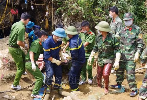 Lực lượng chức năng đưa thi thể ông Giàng Seo Lử ra ngoài. Ảnh: Quốc Khánh/TTXVN