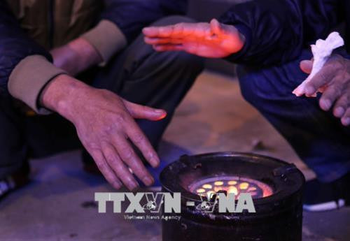 Những người vô gia cư sưởi ấm bằng bếp than để tránh rét. Ảnh: Thành Đạt – TTXVN Những người vô gia cư sưởi ấm bằng bếp than để tránh rét. Ảnh: Thành Đạt – TTXVN