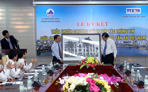 Tổng Giám đốc Thông tấn xã Việt Nam Nguyễn Đức Lợi trao tặng bức ảnh cho Chủ tịch UBND thành phố Đà Nẵng Huỳnh Đức Thơ. Ảnh: Trần Lê Lâm – TTXVN