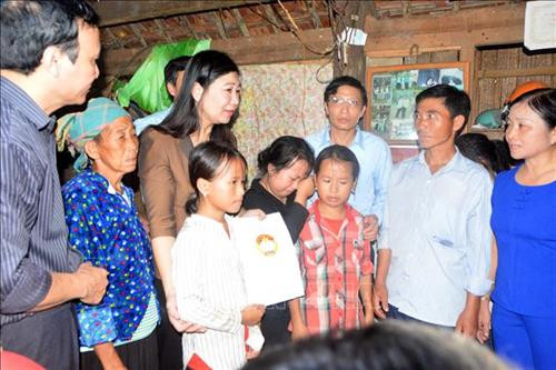 Lãnh đạo Ủy ban MTTQ Việt Nam thành phố Hà Nội (đứng thứ 3, trái sang) trao 30 triệu đồng cho gia đình có người thân bị lũ cuốn trôi ở xã Minh Hương (Hàm Yên, Tuyên Quang). Ảnh: Quang Đán - TTXVN