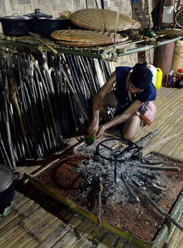 Thầy cúng đổ rượu vào bếp trong nghi lễ mừng nhà mới của dân tộc Bahnar