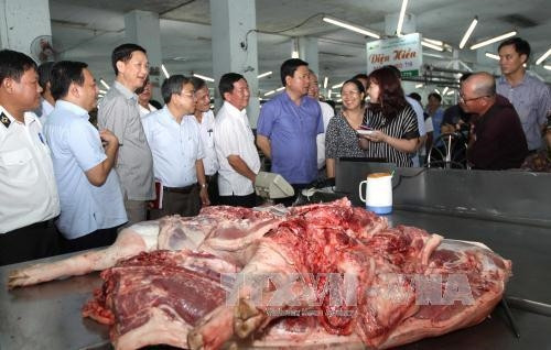 Bí thư Thành ủy Đinh La Thăng tìm hiểu việc truy xuất nguồn gốc thịt lợn kinh doanh tại chợ đầu mối Hóc Môn. Ảnh: Thanh Vũ-TTXVN