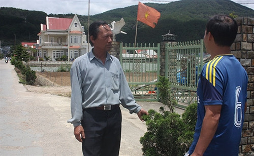 Ông Trị (bên trái) đang thực hiện công tác vận động người dân trong thôn