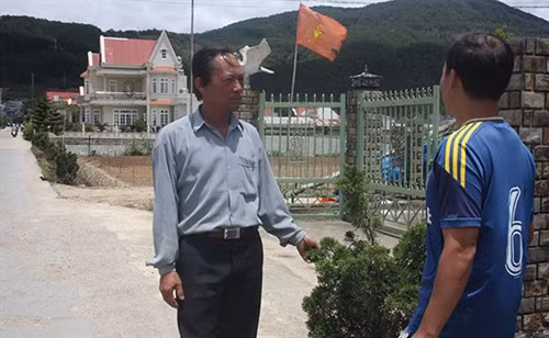 Ông Trị (bên trái) đang thực hiện công tác vận động người dân trong thôn