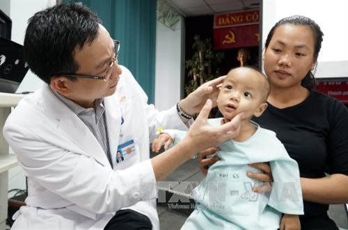 Bác sĩ thăm khám cho bệnh nhi sau phẫu thuật. Ảnh: Phương Vy - TTXVN