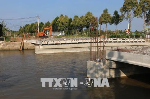 Công trình cầu Tân Hiệp bị ánh xây dựng quá thấp, tàu ghe không thể lưu thông, ảnh hưởng đến sinh hoạt, kinh doanh của hàng trăm hộ dân nơi đây. Ảnh: Duy Khương – TTXVN