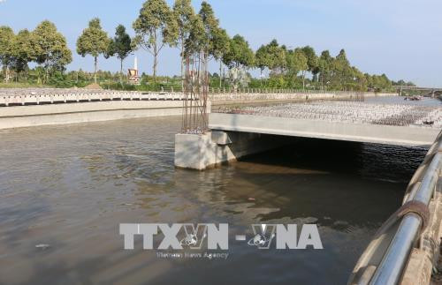 Công trình cầu Tân Hiệp bị ánh xây dựng quá thấp, tàu ghe không thể lưu thông, ảnh hưởng đến sinh hoạt, kinh doanh của hàng trăm hộ dân nơi đây. Ảnh: Duy Khương – TTXVN