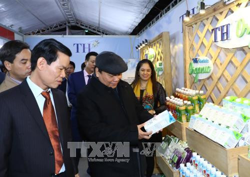 Thủ tướng Nguyễn Xuân Phúc xem và nghe giới thiệu sản phẩm tiêu biểu được trưng bày. Ảnh: Thống Nhất –TTXVN