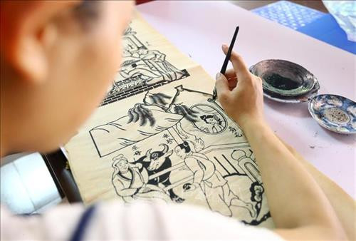 Ngoài tranh được in thủ công, những tranh khổ lớn còn được vẽ thủ công bằng tay. Khi sáng tác mẫu tranh, các nghệ nhân thường sử dụng bút lông và mực Nho để vẽ lên giấy bản mỏng và phẳng để người thợ khắc, đục ván theo mẫu. Ảnh: Minh Quyết – TTXVN Ngoài tranh được in thủ công, những tranh khổ lớn còn được vẽ thủ công bằng tay. Khi sáng tác mẫu tranh, các nghệ nhân thường sử dụng bút lông và mực Nho để vẽ lên giấy bản mỏng và phẳng để người thợ khắc, đục ván theo mẫu. Ảnh: Minh Quyết – TTXVN
