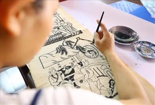Ngoài tranh được in thủ công, những tranh khổ lớn còn được vẽ thủ công bằng tay. Khi sáng tác mẫu tranh, các nghệ nhân thường sử dụng bút lông và mực Nho để vẽ lên giấy bản mỏng và phẳng để người thợ khắc, đục ván theo mẫu. Ảnh: Minh Quyết – TTXVN