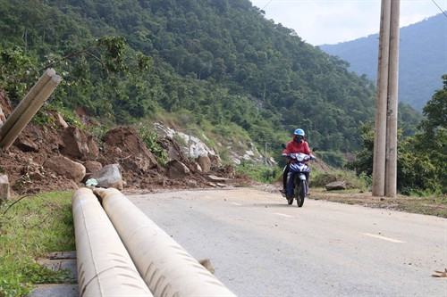 Đất đá trên núi sạt lở xuống đường làm gãy đổ trụ điện.
