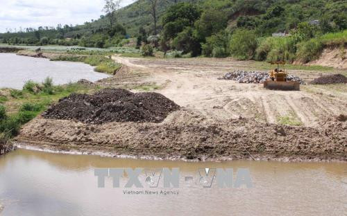 Xã Hòa Phong đang thực hiện thi công đổ đất đá ngăn chặn việc sạt lở bờ sông Krông Bông. Ảnh: Phạm Cường-TTXVN