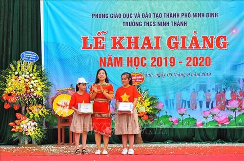 Hiệu trưởng trường THCS Ninh Thành (Ninh Bình) tặng quà cho các em học sinh có hoàn cảnh đặc biệt. Ảnh: Minh Đức - TTXVN Hiệu trưởng trường THCS Ninh Thành (Ninh Bình) tặng quà cho các em học sinh có hoàn cảnh đặc biệt. Ảnh: Minh Đức - TTXVN