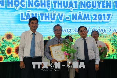 Phó Bí thư Tỉnh ủy Đỗ Hữu Lâm và Phó Chủ tịch UBND Long An Phạm Văn Cảnh, trao giải thưởng cho các tác giả đạt giải. Ảnh: Trần Thanh Bình-TTXVN