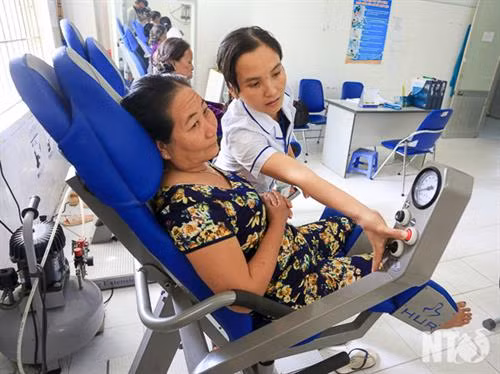 Nhân viên Bệnh viện Y học cổ truyền tỉnh Ninh Thuận hướng dẫn bệnh nhân tập vật lý trị liệu. Ảnh: baoninhthuan.com.vn