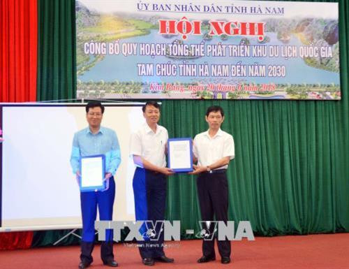Phó Chủ tịch UBND tỉnh Hà Nam Bùi Quang Cẩm (người ngoài cùng bên phải) trao công bố quy hoạch tổng thể phát triển khu du lịch Quốc gia Tam Chúc. Ảnh: Đại Nghĩa - TTXVN