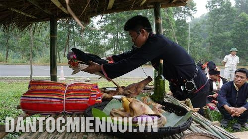 Thầy cúng chuẩn bị lễ vật cúng ngoài gốc cây to của bản. Ảnh: Nam Sương