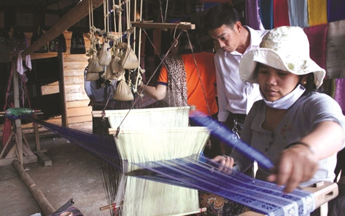 Du khách tìm hiểu nghề dệt thổ cẩm truyền thống của người K’Ho tại làng K'Long, xã Hiệp An, huyện Đức Trọng