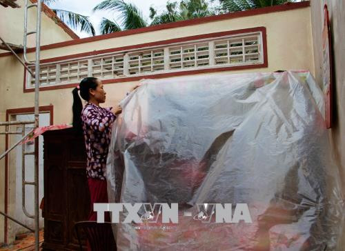 Người dân dọn dẹp nhà cửa sau trận giông. Ảnh: Hồng Thái - TTXVN Người dân dọn dẹp nhà cửa sau trận giông. Ảnh: Hồng Thái - TTXVN