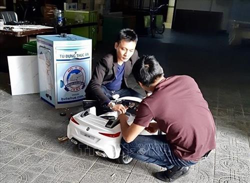 Thạc sỹ Huỳnh Phúc Minh (áo đen) chế tạo robot Tâm An. Ảnh: Mai Trang-TTXVN Thạc sỹ Huỳnh Phúc Minh (áo đen) chế tạo robot Tâm An. Ảnh: Mai Trang-TTXVN
