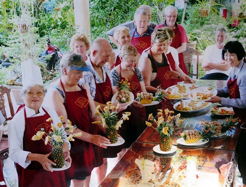 Bà Tôn Nữ Thị Hà (ngoài cùng bên trái) trong một bữa tiệc phục vụ khách du lịch nước ngoài tại Tịnh Gia Viên (ảnh chụp lại)