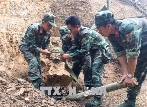 Các Chiến sĩ tiến hành tháo gỡ quả quả bom. Ảnh: Xuân Tư – TTXVN Các Chiến sĩ tiến hành tháo gỡ quả quả bom. Ảnh: Xuân Tư – TTXVN