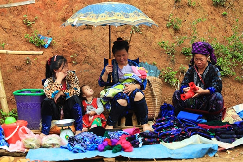 Những phụ nữ người Mông mang theo con xuống chợ. Các nguyên liệu phục vụ dệt thổ cẩm được bày bán nhiều tại chợ. Những phụ nữ người Mông mang theo con xuống chợ. Các nguyên liệu phục vụ dệt thổ cẩm được bày bán nhiều tại chợ.