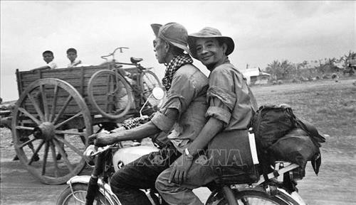 Phóng viên Thông tấn xã Giải phóng Nguyễn Đức Giáp (ngồi sau) cùng đồng nghiệp trên đường tiến về Sài Gòn trong chiến dịch Hồ Chí Minh, tháng 4/1975. Ảnh tư liệu: TTXVN Phóng viên Thông tấn xã Giải phóng Nguyễn Đức Giáp (ngồi sau) cùng đồng nghiệp trên đường tiến về Sài Gòn trong chiến dịch Hồ Chí Minh, tháng 4/1975. Ảnh tư liệu: TTXVN