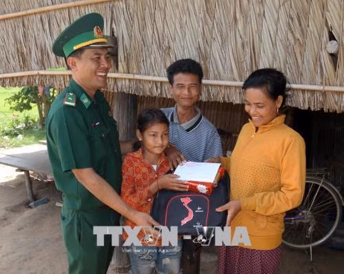 Cán bộ Đồn Biên phòng Phú Mỹ trao quà, tiền cho trẻ hoàn cảnh khó khăn tại ấp Tà Hưng, xã Pray Cơ Rớ, huyện Kampong Trach, (Vương quốc Campuchia). Ảnh: Lê Huy Hải - TTXVN