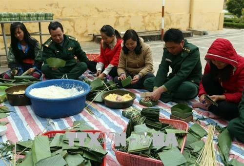 Cán bộ chiến sỹ đồn Biên phòng Mường Pồn cùng người dân gói bánh chưng chuẩn bị đón tết Mậu Tuất 2018. Ảnh: Phan Tuấn Anh – TTXVN Cán bộ chiến sỹ đồn Biên phòng Mường Pồn cùng người dân gói bánh chưng chuẩn bị đón tết Mậu Tuất 2018. Ảnh: Phan Tuấn Anh – TTXVN