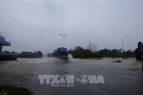 Nước lụt dâng ngập quốc lộ 1A tại km808, thuộc địa phượng thị xã Hương Trà. Ảnh: Hồ Cầu - TTXVN