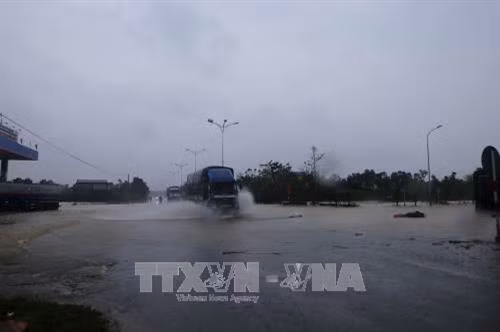 Nước lụt dâng ngập quốc lộ 1A tại km808, thuộc địa phượng thị xã Hương Trà. Ảnh: Hồ Cầu - TTXVN