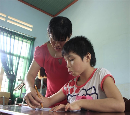 Cô giáo H'Khuin tận tình hướng dẫn từng nét chữ cho các em. Ảnh: Dư Toán - TTXVN. Cô giáo H'Khuin tận tình hướng dẫn từng nét chữ cho các em. Ảnh: Dư Toán - TTXVN.